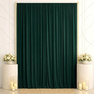 Elegant dark green curtain backdrop with white floral arrangements and candles