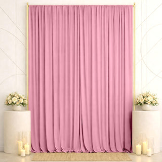 Pink wedding backdrop with gold frame, floral arrangements, and candles