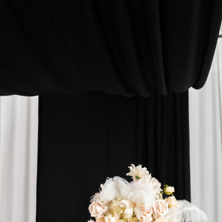 Floral arrangement with feathers against a black and white backdrop.