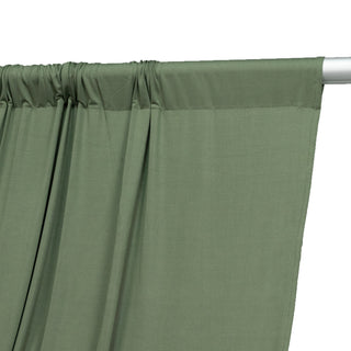 Green curtain fabric draped on a rod, showcasing smooth texture and color.