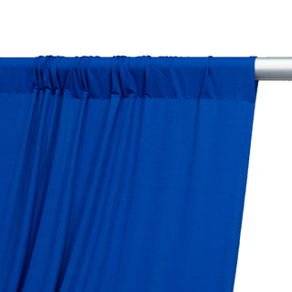 Blue curtain fabric draped on a silver rod against a plain background.
