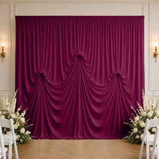 Elegant magenta draped wedding backdrop with white floral arrangements