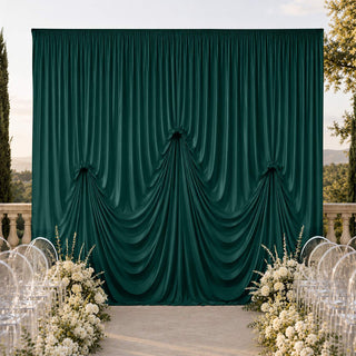 Outdoor wedding backdrop with emerald green draped curtain and floral aisle decor