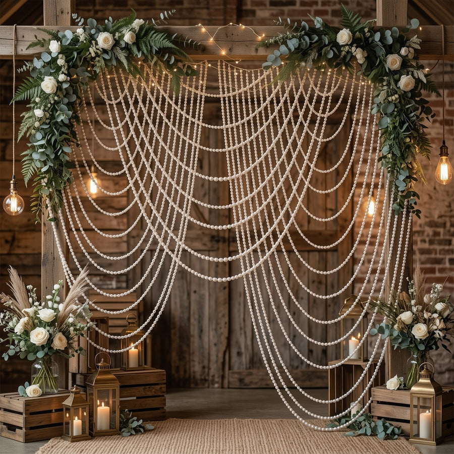 Elegant wedding backdrop with floral arrangements, string lights, and draped pearls.