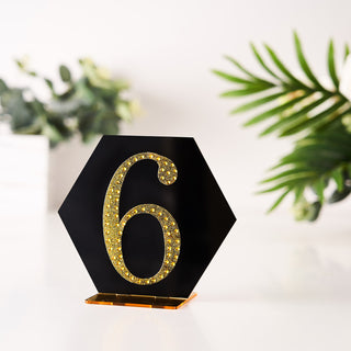 Hexagon table number six with gold glitter on a black base
