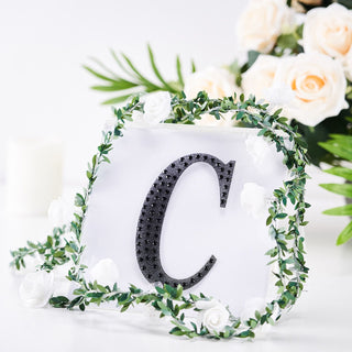 Decorative letter "C" with floral accents on a white background.