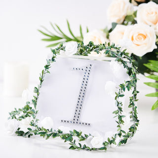 Elegant table number "1" with floral accents and greenery.