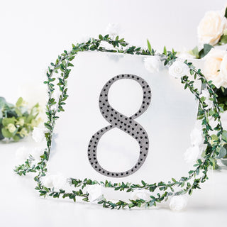 Decorative table number 8 with floral accents and greenery