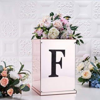 Rose gold floral display box with letter "F" and assorted flowers.