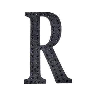 Black decorative letter "R" with stud embellishments