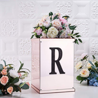 Decorative floral arrangement on mirrored box with letter "R"