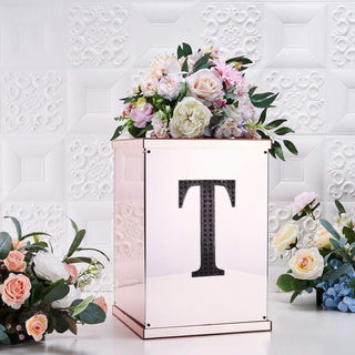 Decorative floral arrangement atop a rose gold box with a letter "T" design.