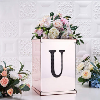 Decorative floral arrangement in a mirrored box with a letter "U" design.