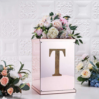 Rose gold floral arrangement box with initial "T" and decorative flowers.