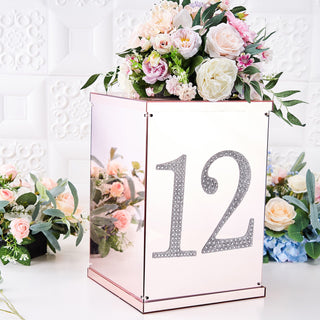Rose gold table number display with floral arrangement on top, number 12.