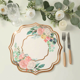 Floral decorative plate with gold trim on a dining table setting.
