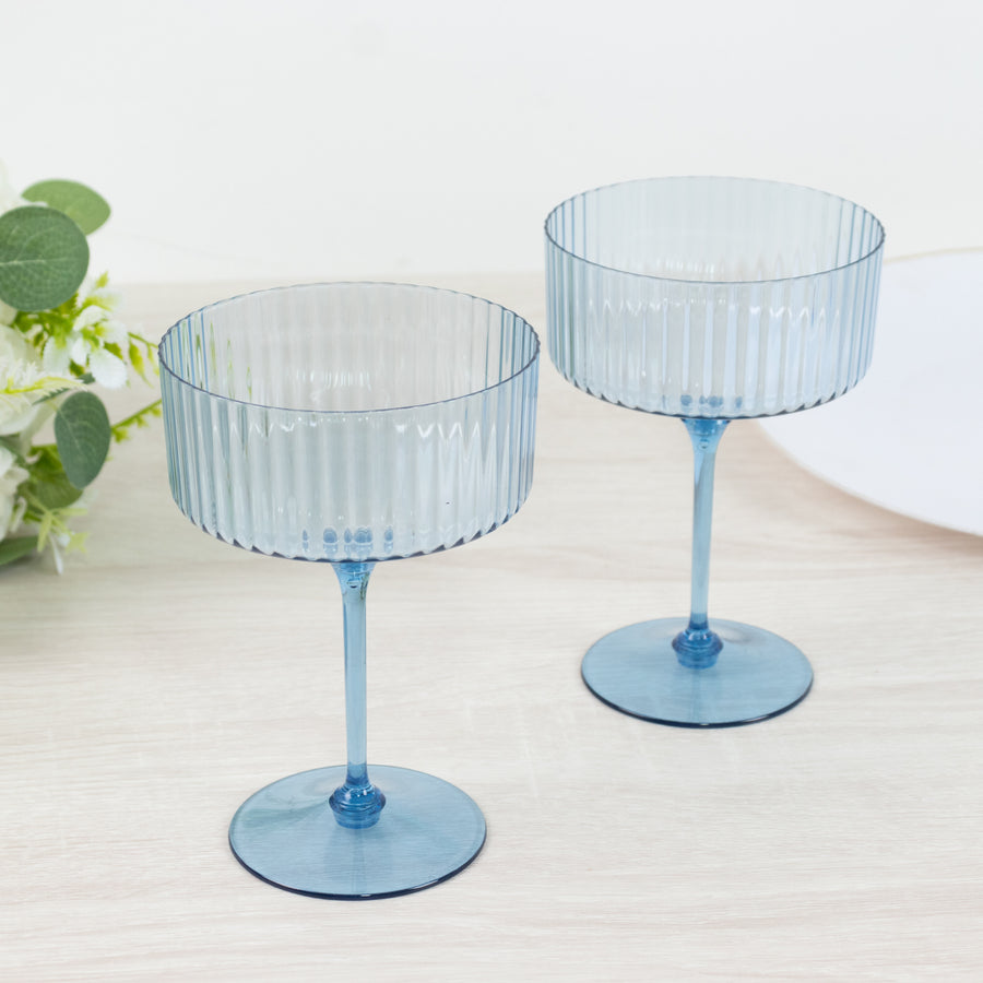 Blue ribbed glass dessert bowls on a wooden surface.