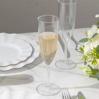 Elegant champagne flute on a dining table with plates and flowers.