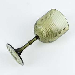 Green ribbed wine glass with a fluted design on a white background