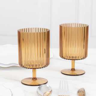 Amber ribbed glasses on a marble table setting.