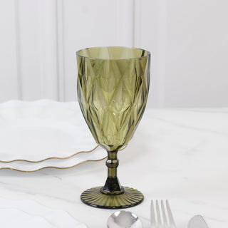 Green decorative glass on a marble surface with white plates in the background.