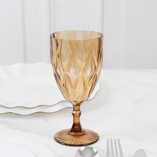 Amber glass goblet with diamond pattern on a marble table.