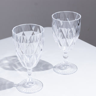 Set of two crystal glass goblets with diamond cut patterns.