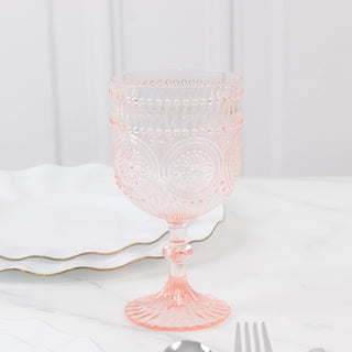 Pink decorative glass goblet with intricate patterns and a stem.