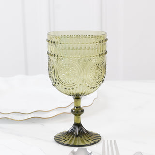 Green glass goblet with intricate design and stem.
