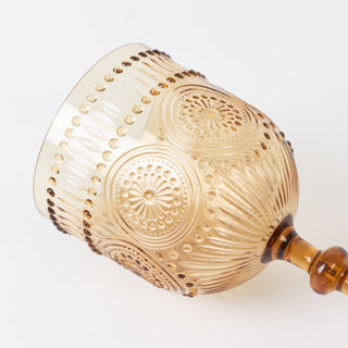 Amber decorative glass goblet with intricate patterns and a fluted design