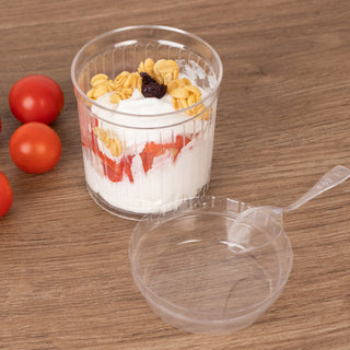 Yogurt parfait with granola and berries in a clear cup, spoon on the side.