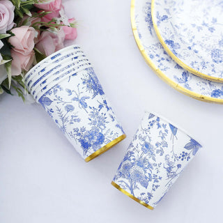Floral patterned paper cups with gold trim on a white background.