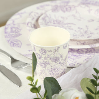 Floral-patterned disposable cup beside elegant tableware setting.