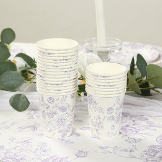 Stack of floral printed disposable cups on a table with greenery.