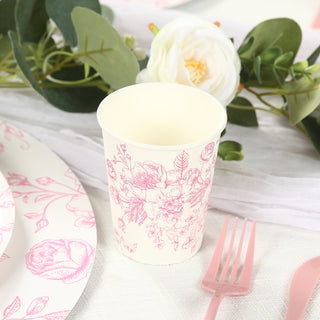 Pink floral paper cup on a table setting with decorative elements.
