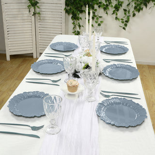 Elegant blue dinnerware set arranged on a dining table with floral centerpiece.