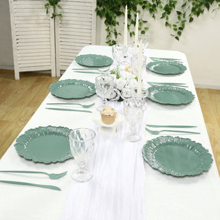Elegant green dinnerware set arranged on a white table with candles and decor.