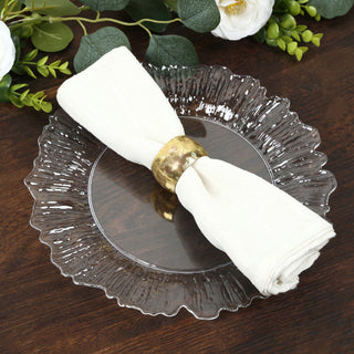 Elegant white napkin with gold ring on decorative glass plate.