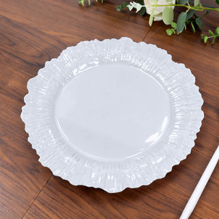 White decorative plate with a ruffled edge on a wooden surface.