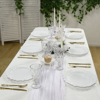 Elegant dining table set with white plates, glassware, and floral centerpiece.