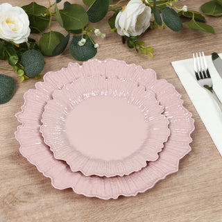 Stacked pink decorative plates on a wooden table with floral accents.