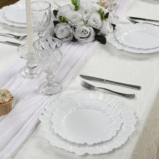 Elegant white ruffled dinner plates set on a beautifully arranged dining table.