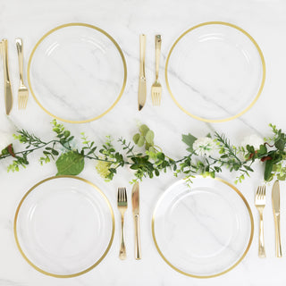 Elegant gold-rimmed plates set on a marble table with greenery