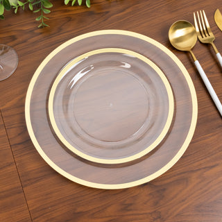 Elegant clear plate with gold rim on wooden table setting.
