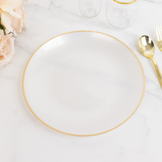 Elegant white plate with gold rim on marble surface.