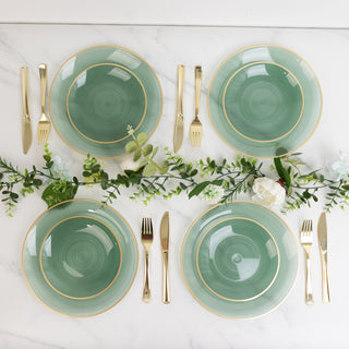 Elegant green dinner plates with gold trim and cutlery on a marble table.