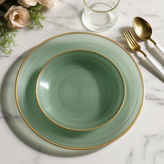 Elegant mint green dinnerware set with gold accents on a marble surface.