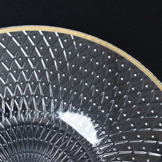 Cut glass plate with intricate diamond pattern and gold rim.