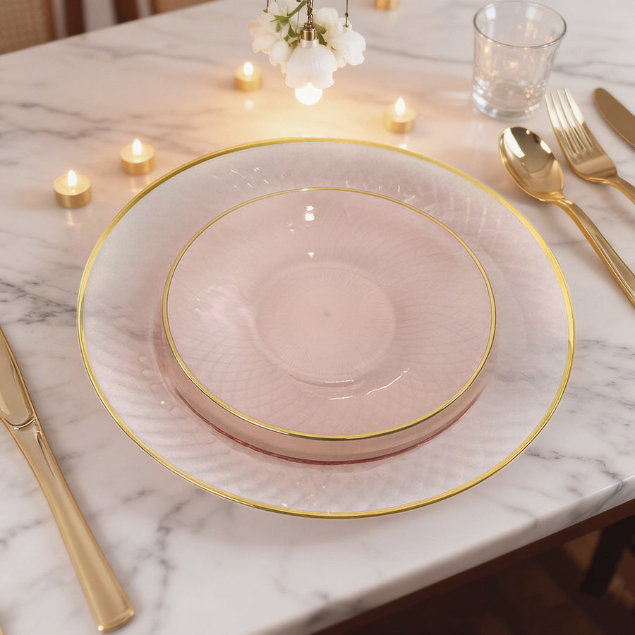Elegant pink dinner plates with gold trim on a marble table.