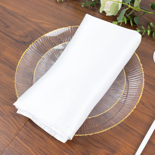 White napkin elegantly folded on a glass plate.